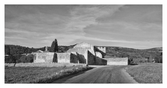Black and white photograph of a stone building with a road leading to it, Black and white fine art landscape photograph of a rustic, isolated Italian farmhouse in the region of Abruzzo.
