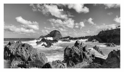 Black and white landscape of a rocky coastline with waves and clouds, Black and white fine art seascape of a rugged coastline in Madeira, Portugal, with Atlantic Ocean waves crashing against the rocks