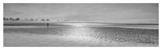 Black and white landscape of a beach with a person standing in the distance. Monochrome landscape print of the vast, open sands and minimalist coastline of Camber Sands, UK.	97	Focuses on the geographical location and minimalist theme.
