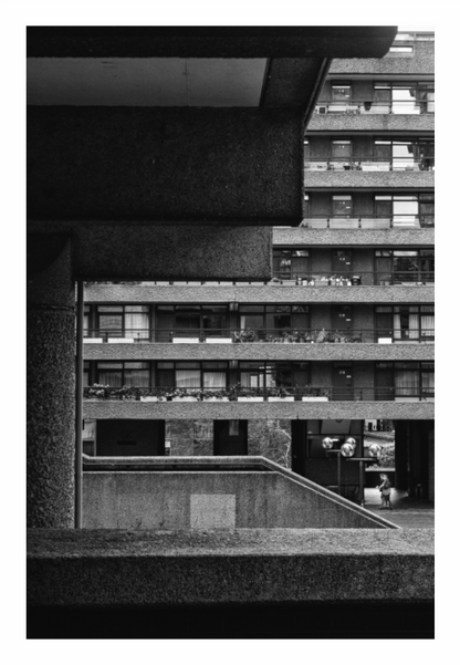 Black and white architectural photograph of a modern building with balconies, Monochrome photo highlighting the tall, stark, geometric facade and windows of the Barbican Centre.